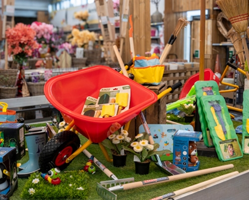 Brouette rouge et outils de jardinage pour enfants exposés en magasin